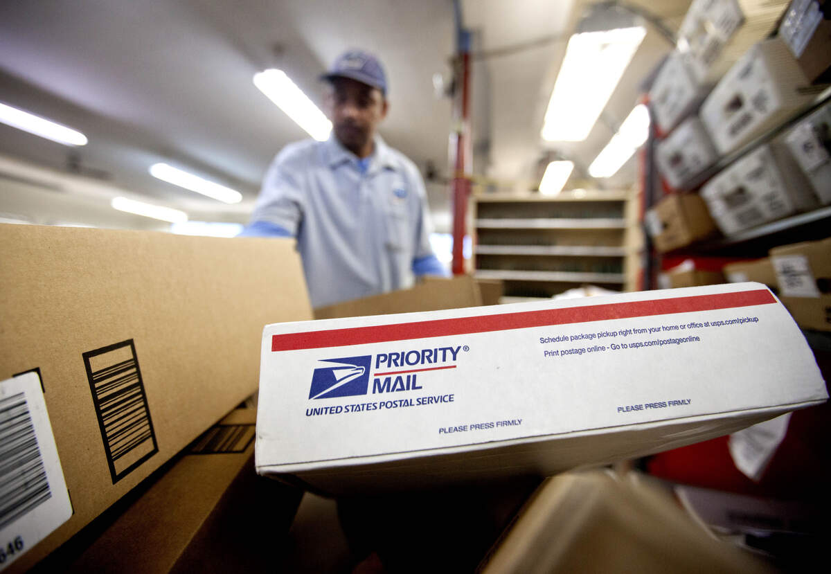 Packages wait to be sorted in a post office in this 2013 file photo.