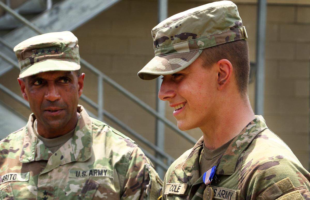 In a ceremony Tuesday at Fort Moore, Pvt. Matthew Cole, right, was presented with the Soldier’s Medal by Gen. Gary Brito, commander of the Army’s Training and Doctrine Command. ​Cole was presented the Soldier’s Medal for his heroic actions that saved a 3-year-old girl and her father from the rising Chattahoochee River while he was off duty May 26 in Columbus. 08/08/2023