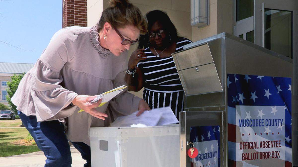 Nancy Boren, executive director of the Muscogee County Board of Elections and Registrations, left, and Talisha Austin, elections specialist, collect ballots Thursday afternoon from a new ballot drop box at the City Services Center in Columbus, Georgia. This drop box first was just installed at the City Services Center in Columbus, Georgia, with more to follow. It’s bolted to the concrete and will remain open until 7 p.m. on Election Day.