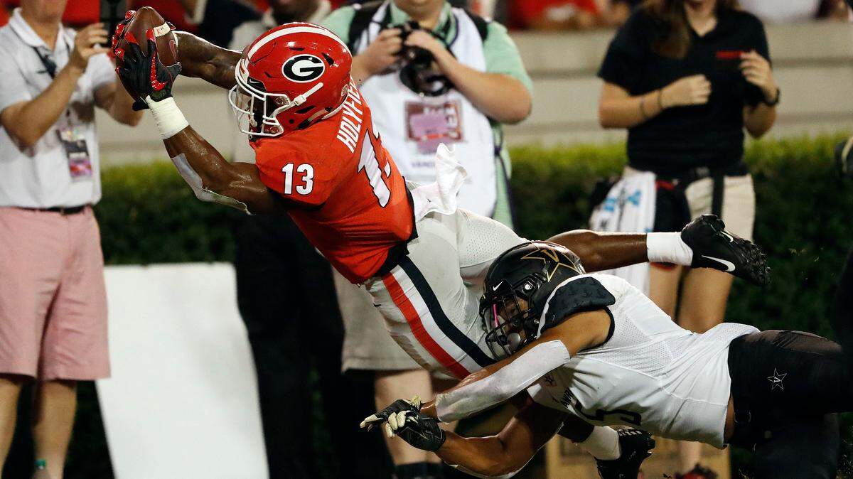 Georgia running back Elijah Holyfield (13) dives into the end zone for a touchdown as Vanderbilt safety LaDarius Wiley (5) defends during the first half of an NCAA college football game Saturday, Oct. 6, 2018, in Atlanta, Ga. (AP Photo/John Bazemore)