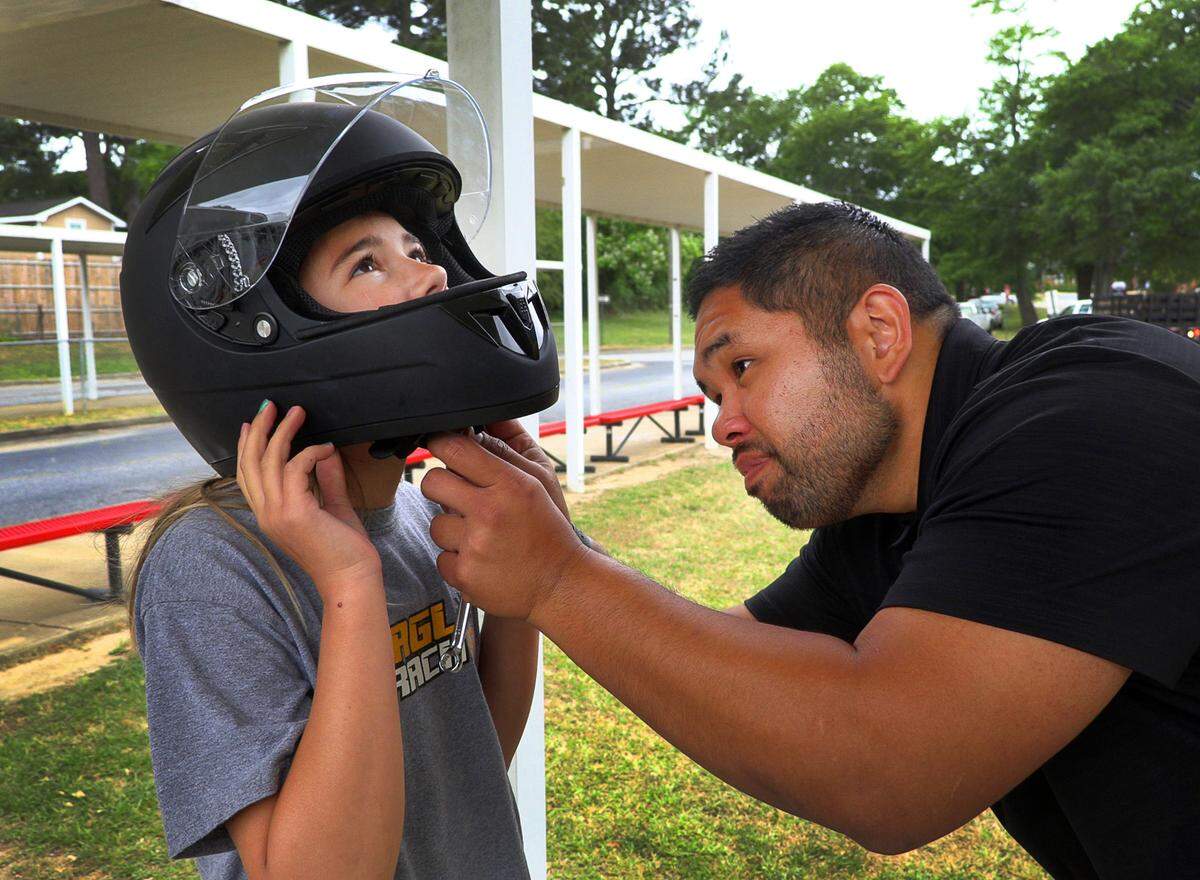Assistant coaches J.P. Aguirre helps Anna McQuien remove her racing helmet. 05/12/2022