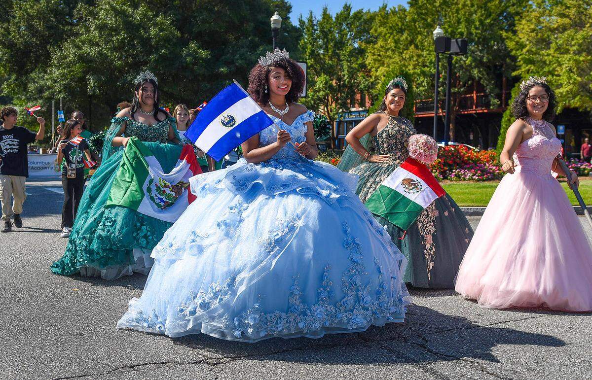 Amaya Glover (blue dress) leads the four women in their Quinceañeras dresses at the Tri-City Latino Festival parade Saturday morning.