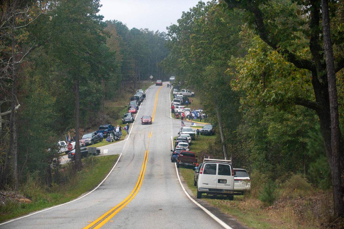 President Donald Trump and Joe Biden supporters line the road outside of Mountain Top Inn and Resort to greet the Democratic presidential nominee as he holds a campaign speech on Oct. 27, 2020 in Warm Springs, Georgia.