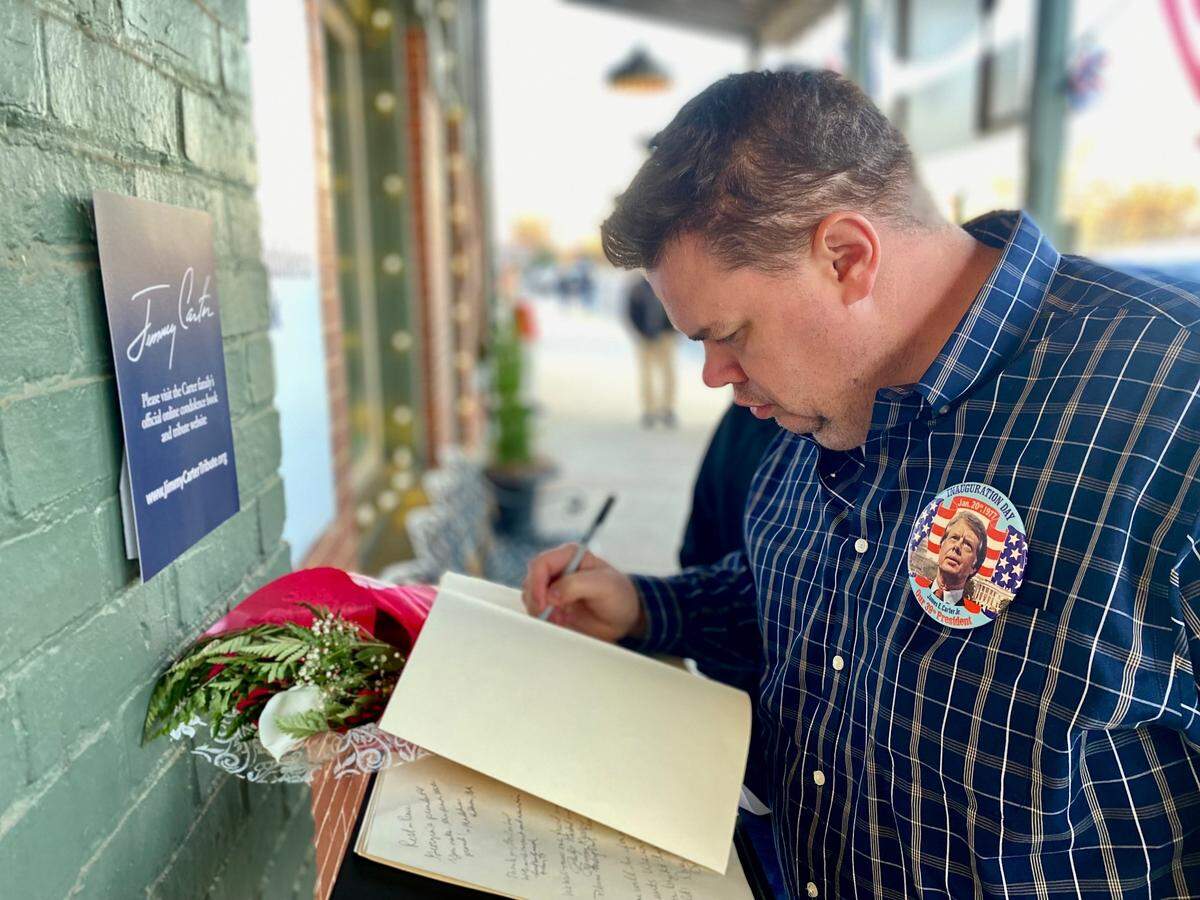 Alan Bowers of Warner Robins signs a condolence book for Jimmy Carter on Saturday morning, Jan. 4, 2025. The book is located on Main st. In downtown Plains, GA.