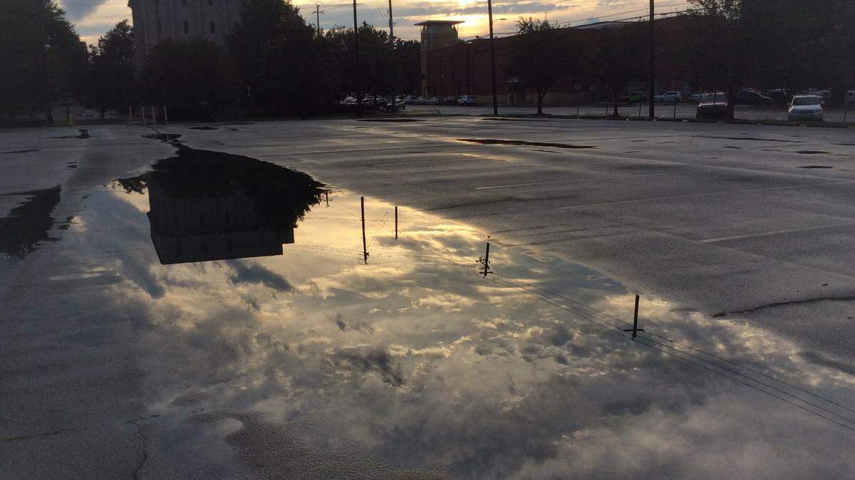 A puddle reflects the late spring sunset in a parking lot across from the Columbus Government Center. Friday will be the longest day of 2019 as the summer solstice arrives.