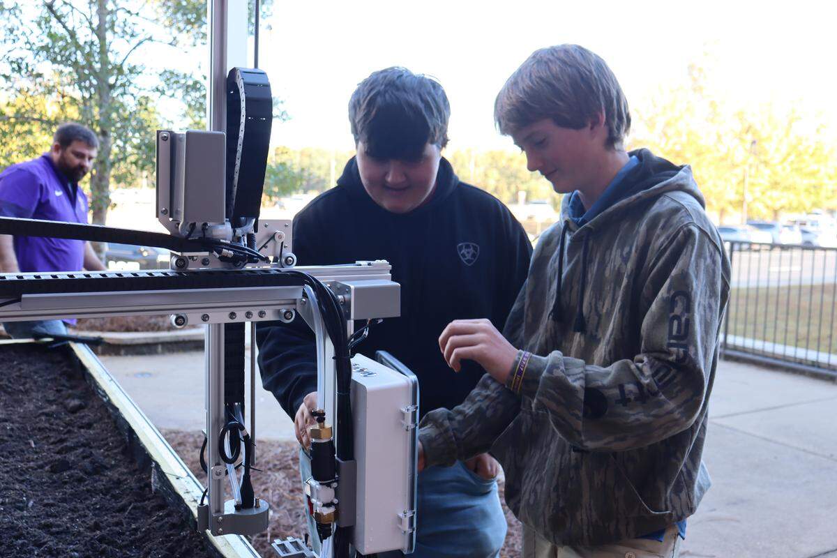 Bainbridge High 10th graders inspecting their new Farmbot on the garden bed outside the high school. (Rylan Godwin and Gavin Hughes)