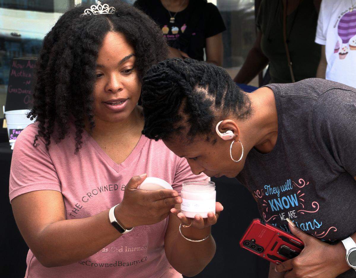 Kristi Pitts, left, the owner of The Crowned Beauty Co., is preparing to open a brick-and-mortar Crowned Beauty Co. store in downtown Columbus in the Rankin Building on 10th street later this month. She will continue to offer her products during Market Days on Broadway. 05/04/2024