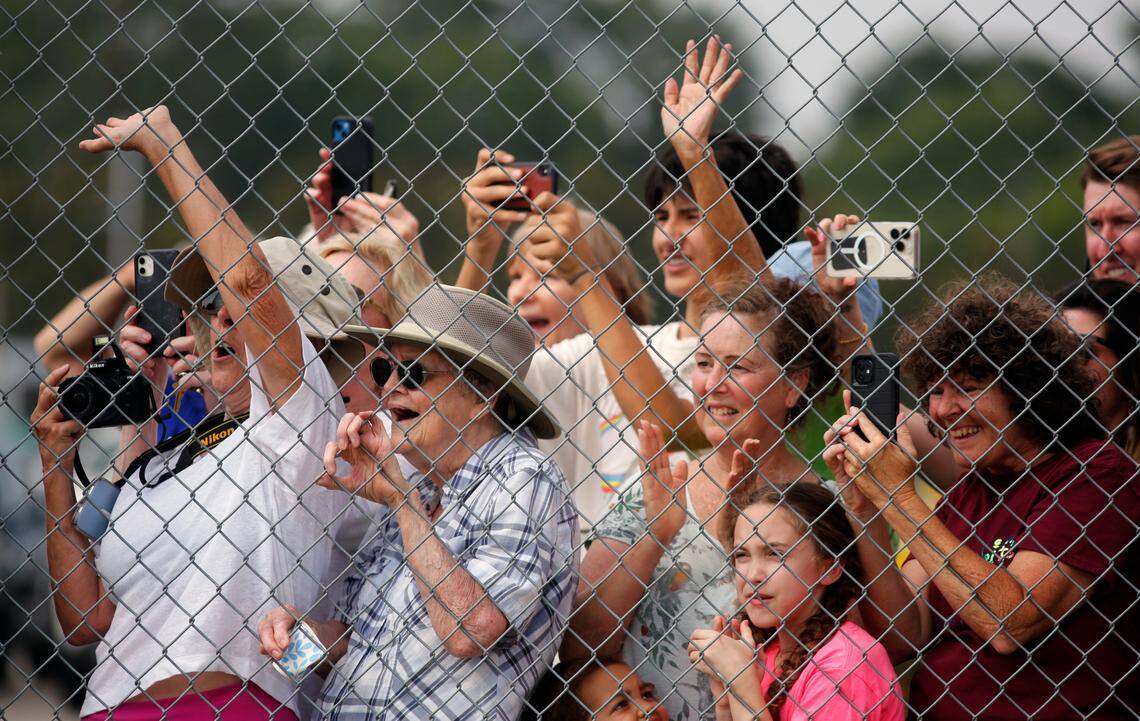 Supporters of former president Donald Trump wave as he boards a plane at the Columbus Airport to leave Columbus, Georgia. 06/10/2023