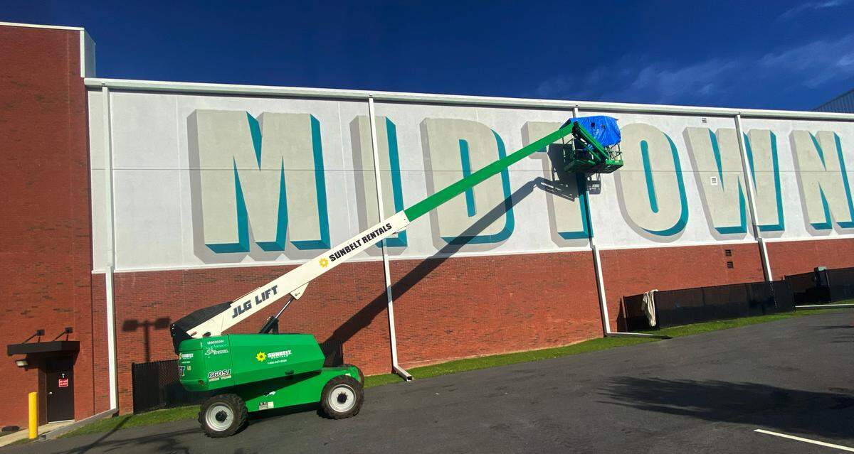 Artists Chris Johnson and Michael Burke begin painting a new mural on Extra Space Storage at Cross Country Plaza in midtown Columbus on July 14, 2025.
