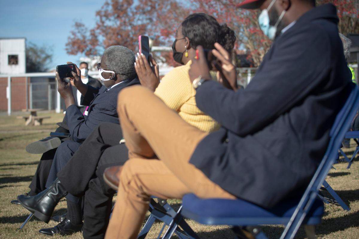 The crowd records Sen. Jon Ossoff speaking on Nov. 23, 2021, at the METRA Transit System in Columbus, Ga. Ossoff and other Georgia Democrats are traveling through the state to recognize the bipartisan infrastructure deal passed last week.