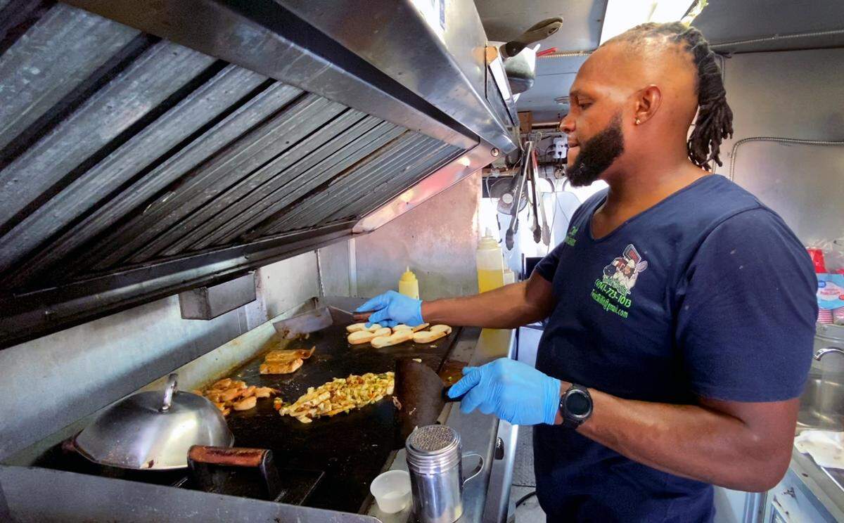 Jerome Lawson, the owner of Twist Skillit food truck in Columbus, Georgia, prepares a dish that includes shrimp, salmon, and vegetables. 10/13/2021