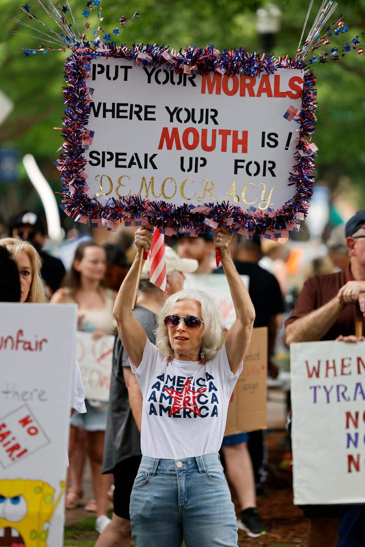 Hundreds of people gathered Saturday morning in the 900 block of Broadway in downtown Columbus, Georgia for a “No Kings” themed demonstration. Many demonstrators held signs such as this one.