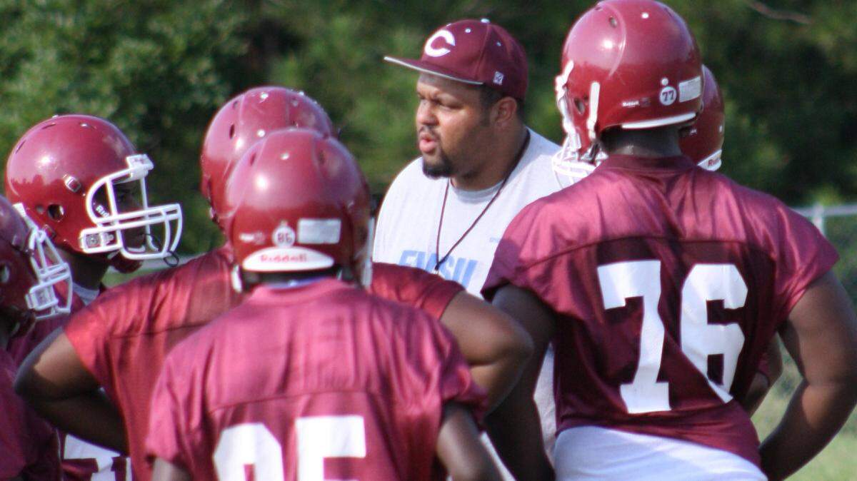 CHRIS WHITE/cwhite@ledger-enquirer.com 
 Carver football assistant coach and co-athletic director Joseph Kegler talks with players during a break at practice on Wednesday. Kegler played in the Carver-Spencer game as a lineman at Carver from 1997-2000 and now coaches in it.