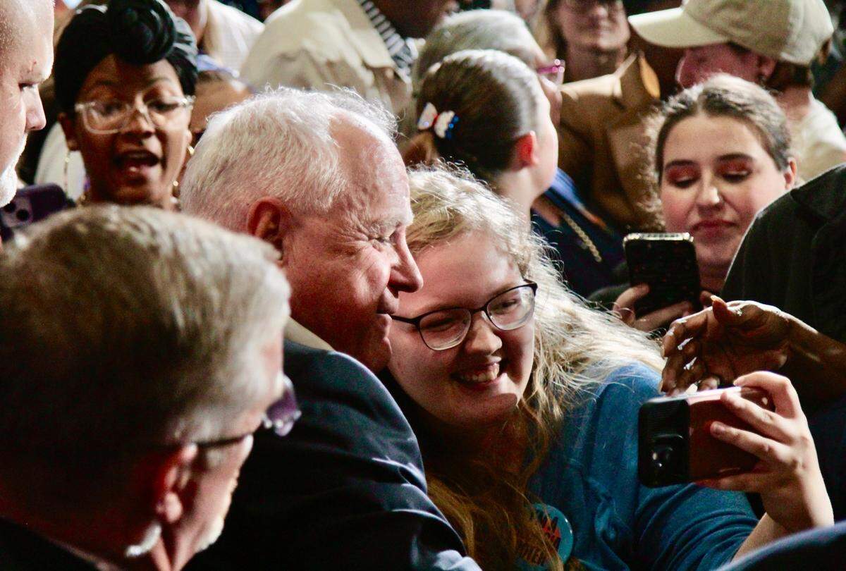 Minnesota Gov. Tim Walz, the Democratic nominee for vice president, takes a selfie with a supporter in Columbus, Georgia. Walz visited Columbus on Oct. 29, 2024, for a rally.