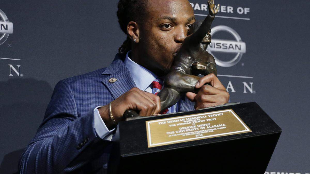 Alabama's Derrick Henry kisses the Heisman Trophy while posing for photos after winning the award as the country's top college football player, Saturday, Dec. 12, 2015, in New York. (AP Photo/Julie Jacobson)