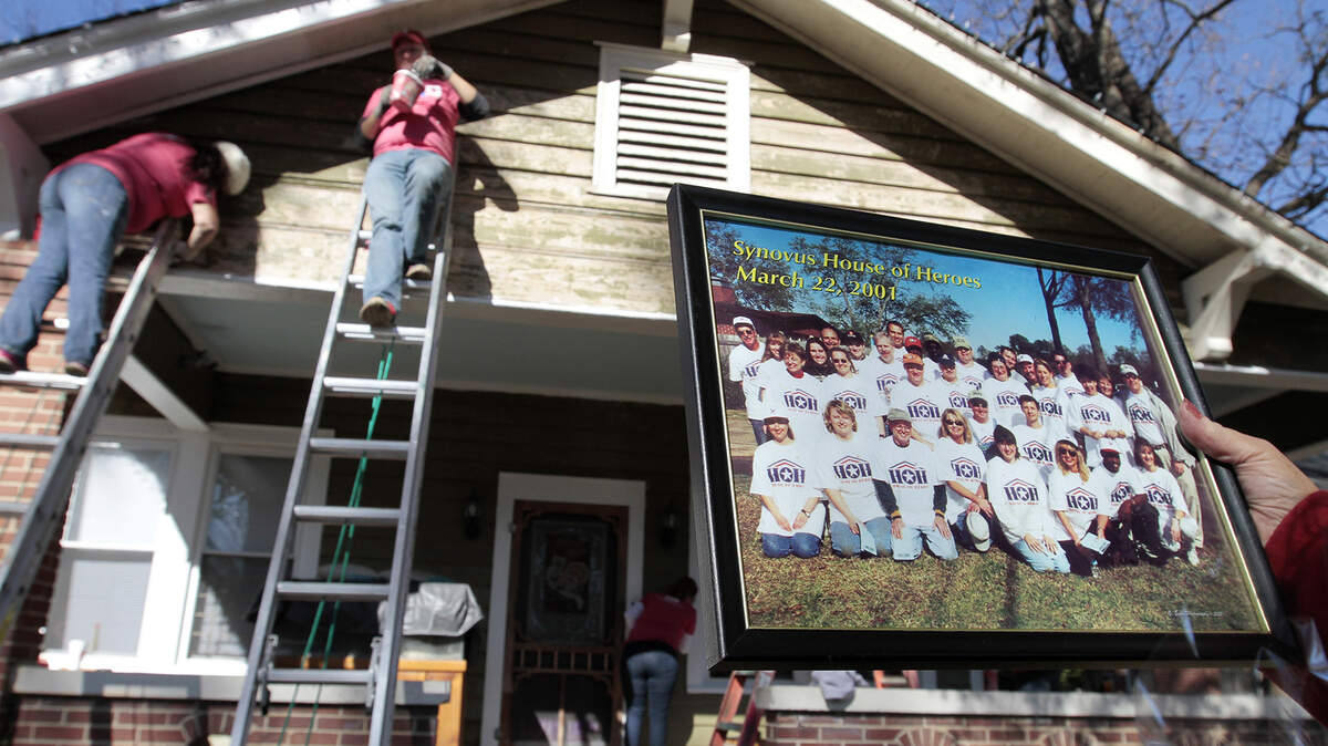 A crew of Synovus volunteers paint the home of retired U.S. Army Sgt. Anna Lopardo Tuesday, the1000th House of Heros home nationwide. A Synovus team was the first corporate-sponsored HOH home in March 2001 in Columbus, where the charitable program was founded in 2000.