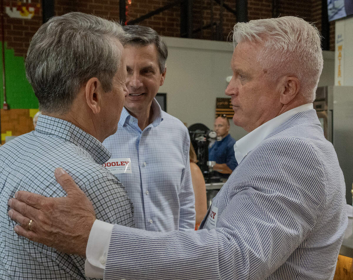 Former college football coach Derek Dooley, center, a Republican candidate for U.S. Senate, and Gov. Brian Kemp, left, talk with state Sen. Randy Robertson (R-Cataula) during Dooley’s campaign stop June 12, 2026, in Columbus.