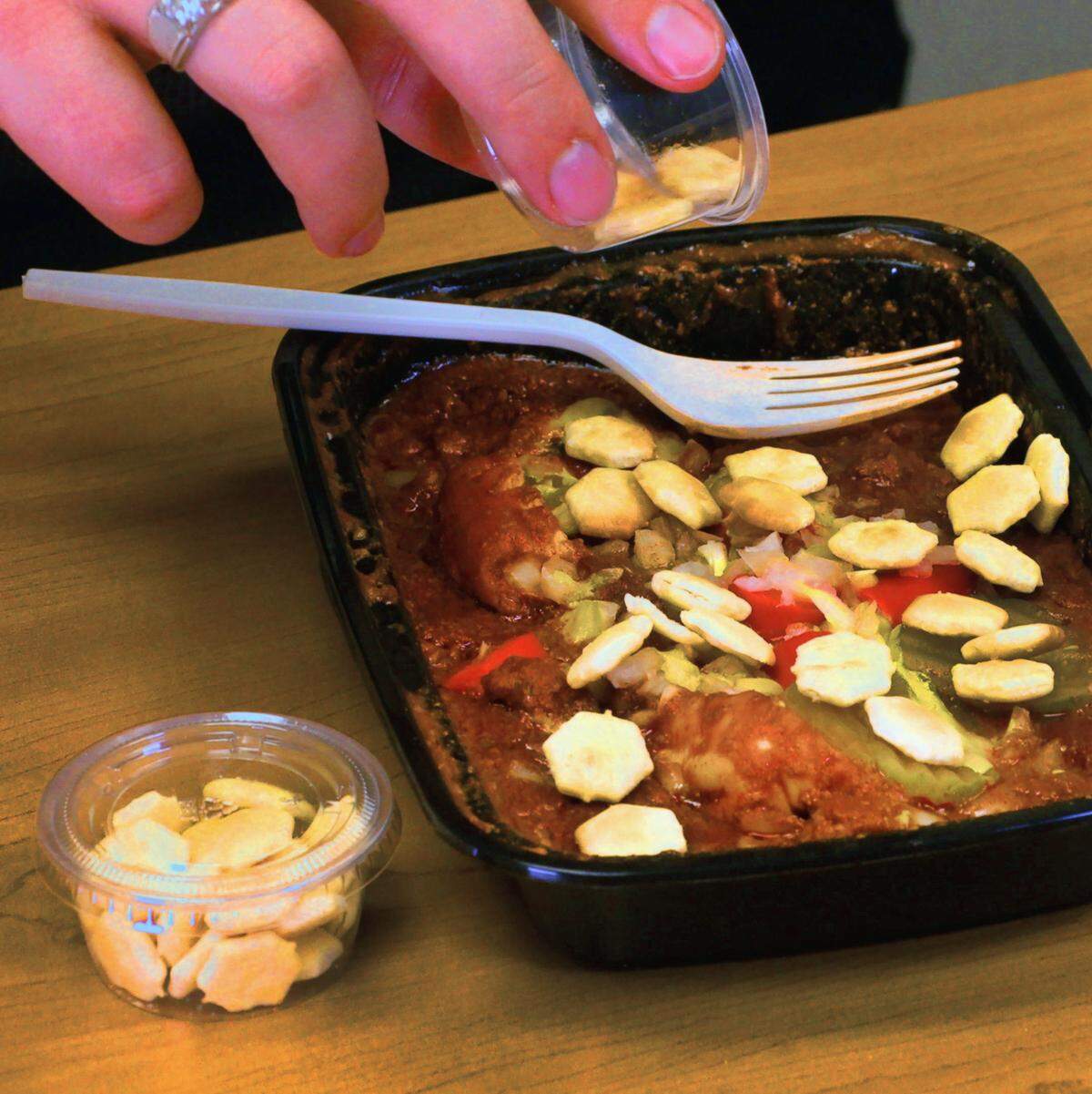 Ledger-Enquirer reporter Kelby Hutchison adds oyster crackers to a Scrambled Dog from Dinglewood Pharmacy in Columbus. Hutchison did a blind taste test of Scrambled Dogs from six Columbus restaurants to determine which he likes the best.