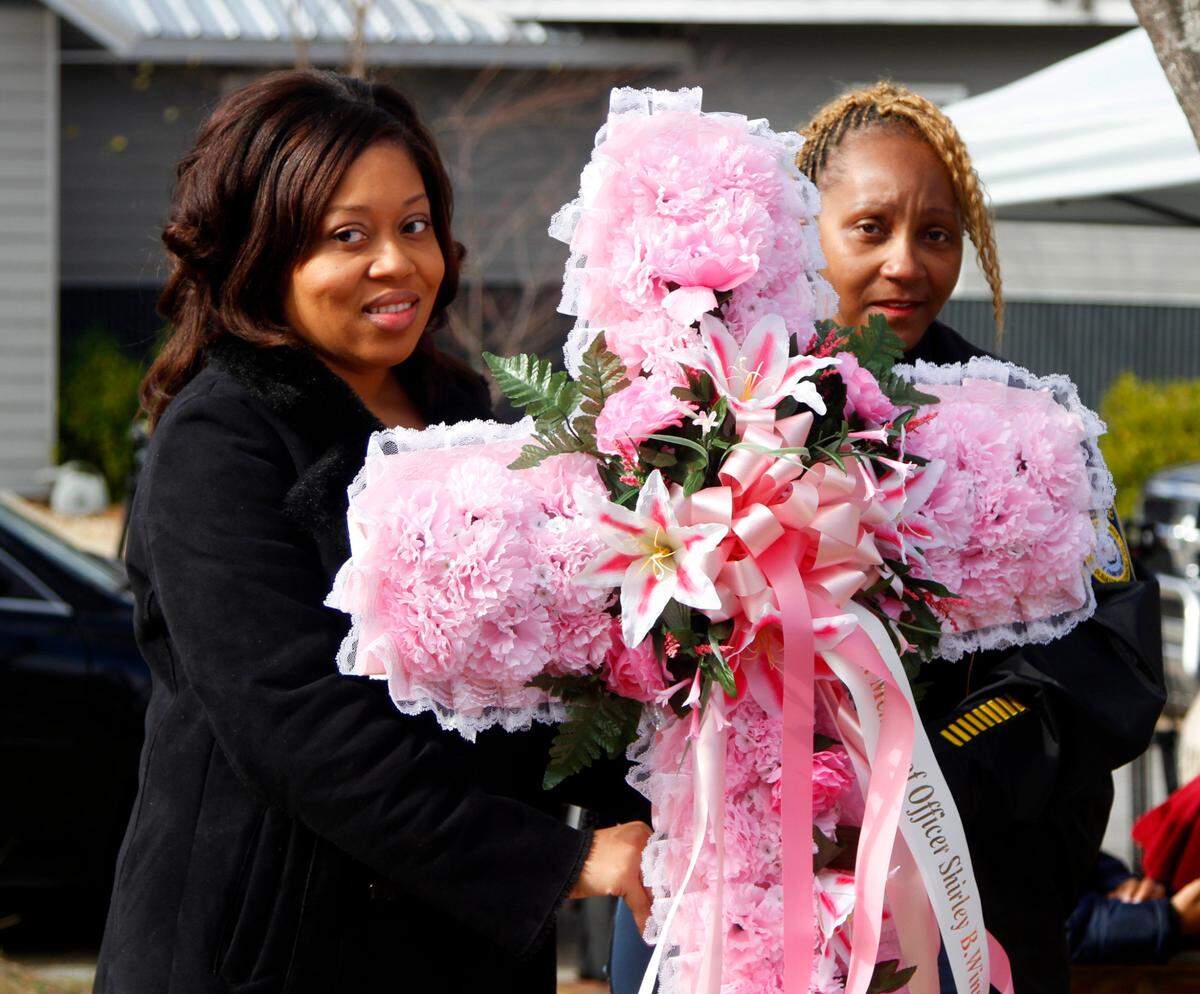 Vanessia Blanding, daughter of fallen police officer Shirley B. Winston, and Columbus police Lt. Joyce Dent-Fitzpatrick hold a wreath dedicated to WInston during a ceremony in her honor in Bibb City.