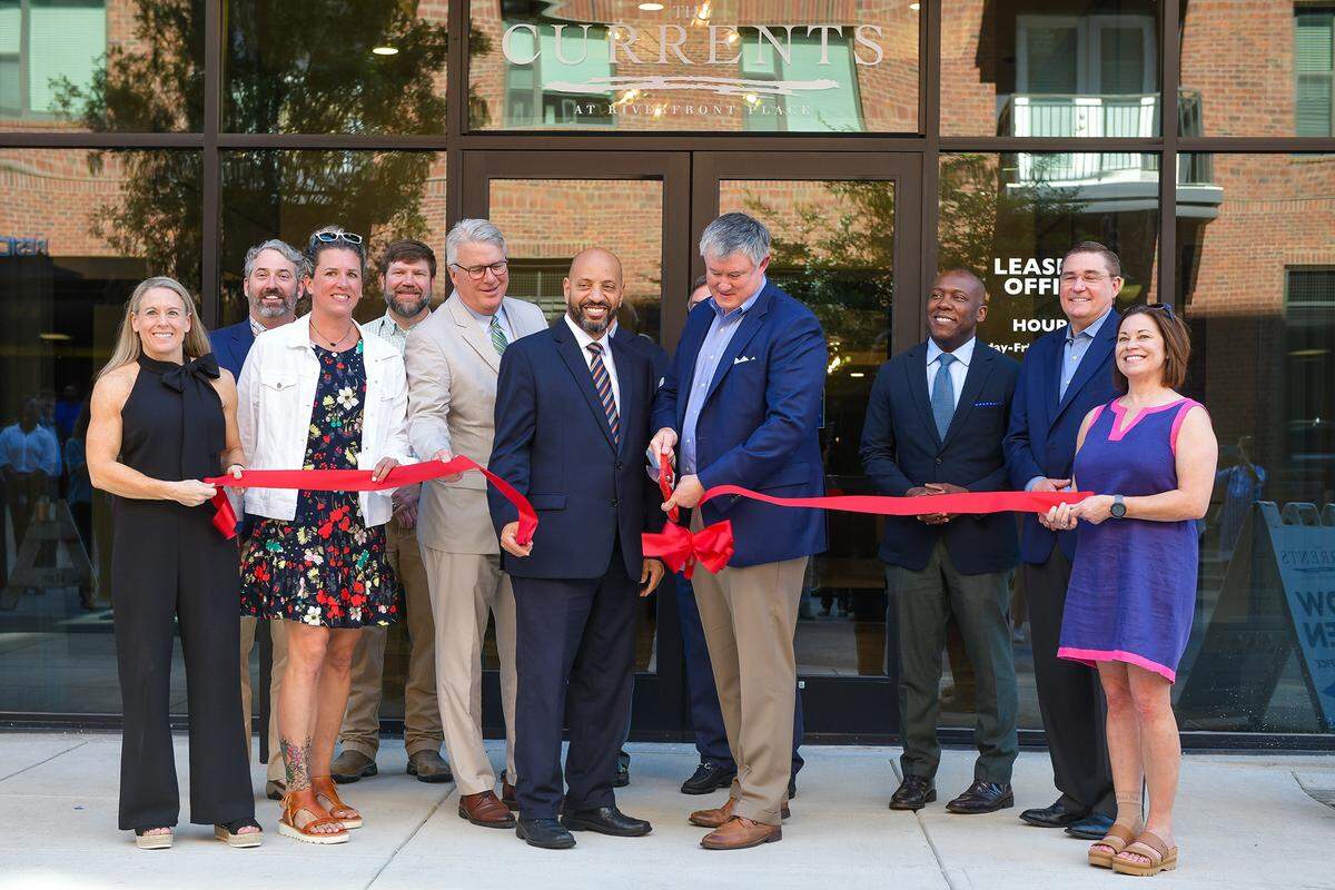 Pace Halter, president & chief operating officer of W.C. Bradley Co. Real Estate, and Columbus City Councilor Bruce Huff, lead other city officials and guests in cutting the ribbon at the grand opening of The Currents at Riverfront Place on Wednesday morning. 05/01/2024