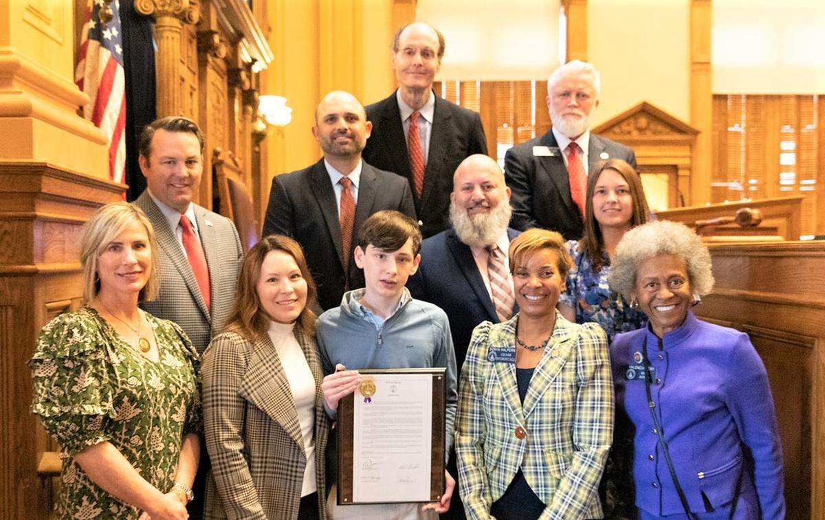 Brookstone School eighth-grader Collin Etheridge and staff were recognized Feb. 23, 2023, by the Georgia Legislature. The Brookstone contingent came to the State Capitol in Atlanta to advocate for more CPR and AED training in schools. Pictured are, from left: front row, Brookstone nurse Linda Sheffield, Meghann Etheridge, Collin Etheridge, state Sen. Sonya Halpern and state Sen. Valencia Seay; second row, Lt. Gov. Burt Jones, Brookstone faculty member Nate McConnell, Muscogee County sheriff’s deputy Jonnie Ellerbee and Brookstone faculty member Lucy Pound; back row, Brookstone head of school Marty Lester and state Sen. Randy Robertson.