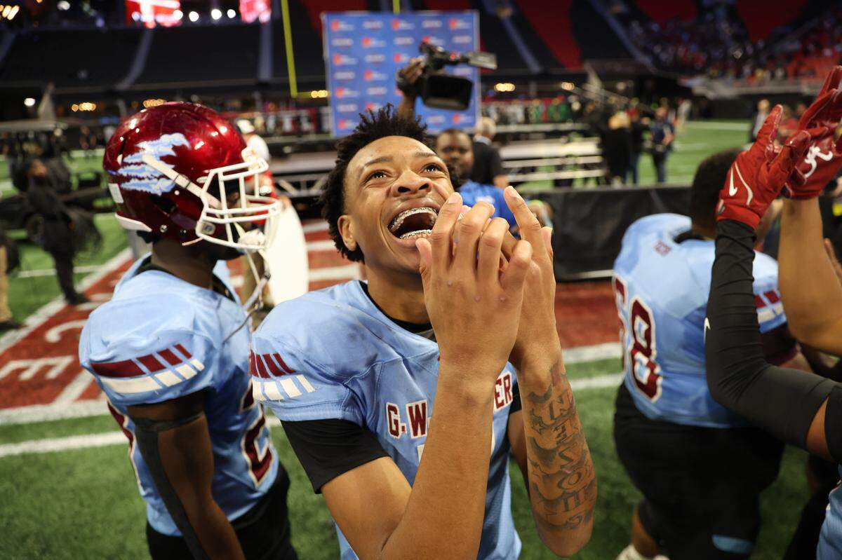 Carver High School junior quarterback Matthew Mungin III (7) points at his ring finger after winning the 2AA GHSA State Football Championship against Burke County High School on Tuesday, Dec. 17, 2024, at Mercedes-Benz Stadium in Atlanta, Georgia. Carver Tigers defeated the Burke County Bears 54-12 to win the state title.