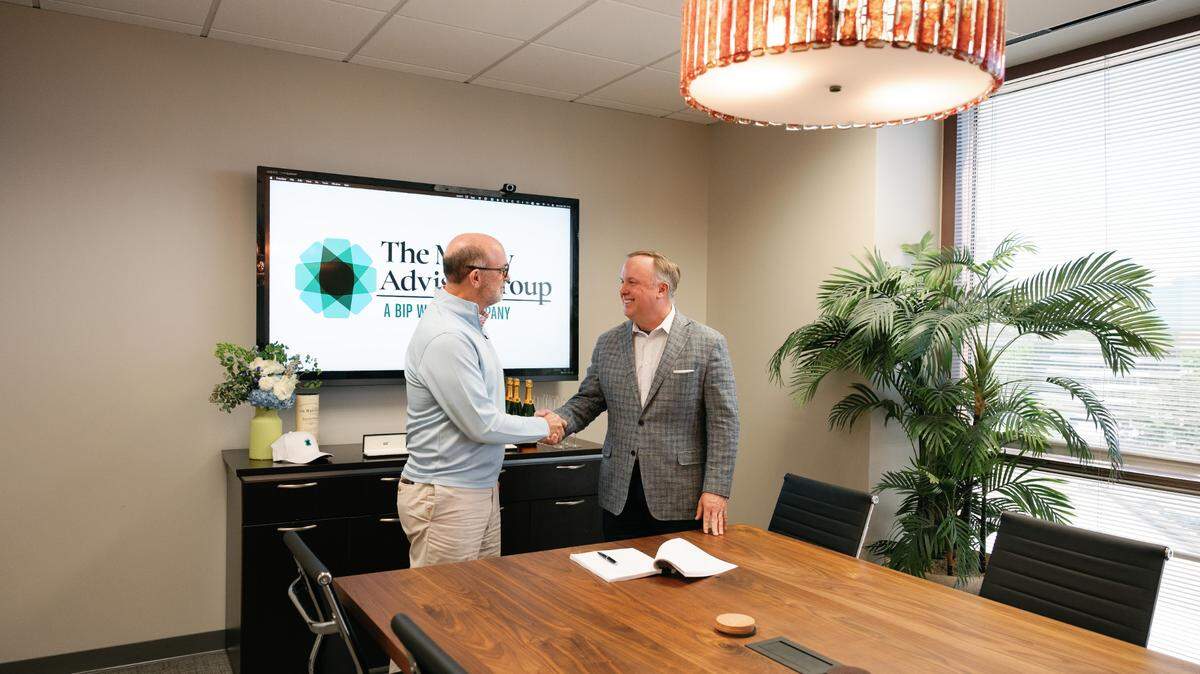 Tim Money (left), president of The Money Advisor Group, and Bill Harris (right), CEO of BIP Wealth, mark the formalization of the firms’ partnership on April 22 during a signing ceremony.