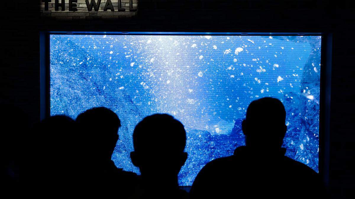 Attendees look at Samsung’s “The Wall” modular television at CES International on Jan. 10 in Las Vegas.