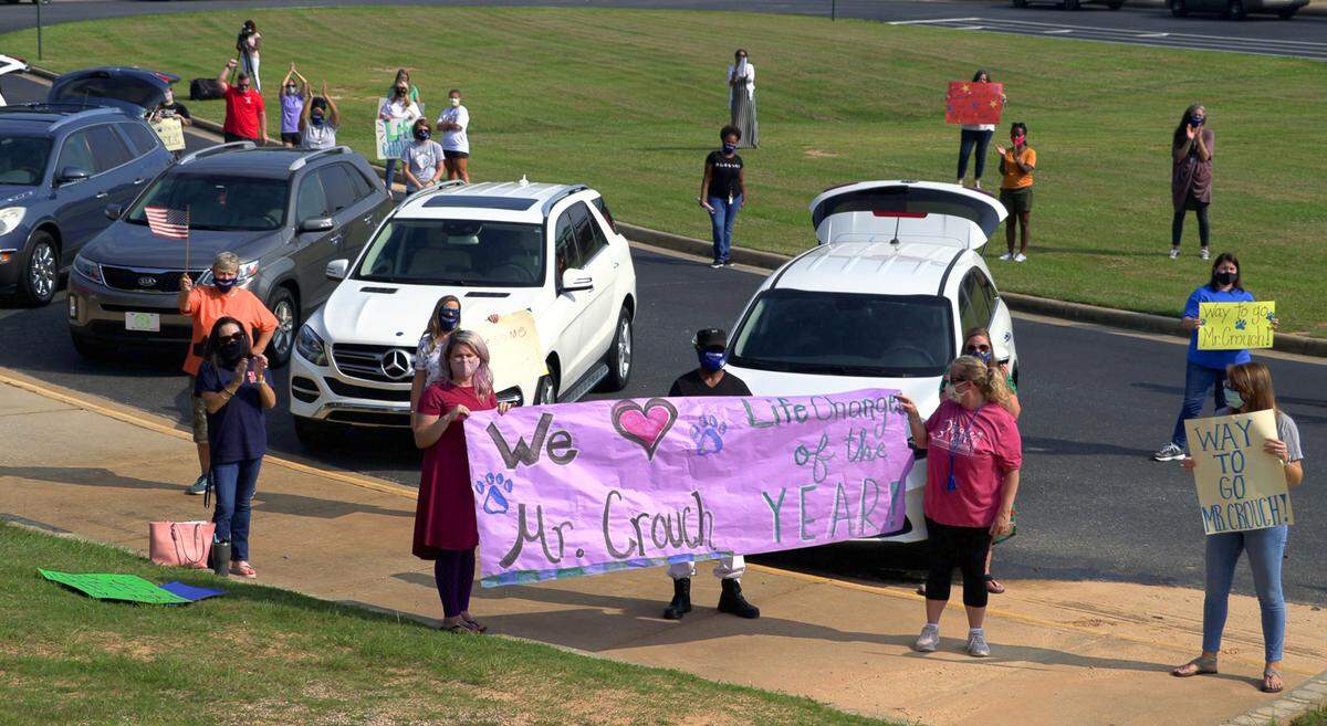 Faculty and staff and Double Churches Elementary School in Columbus, Georgia look on as Eric Crouch, a fifth-grade teacher at Double Churches Elementary School, learns he is the grand prize winner of the 2019-20 LifeChanger of the Year award. Officials surprised Crouch with the announcement Friday. The $10,000 prize will be split, $5,000 each for the teacher and the school. More than 850 teachers, administrators and other employees in school systems from all 50 states and the District of Columbia were nominated.