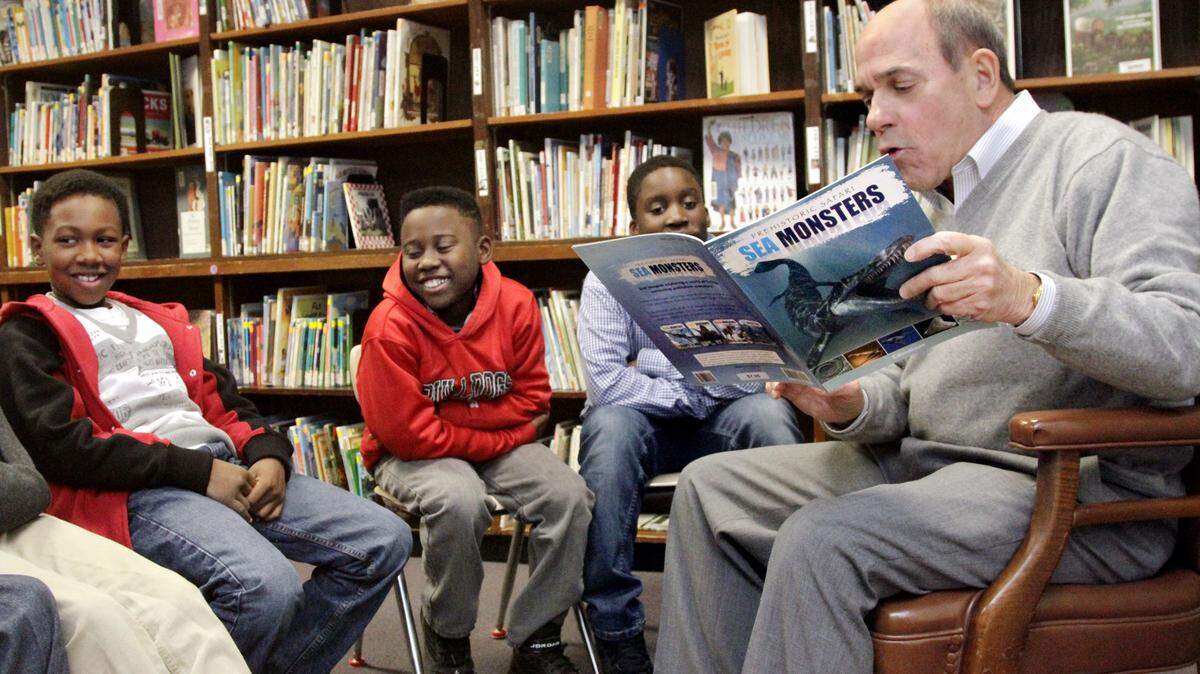 ROBIN TRIMARCHI/rtrimarchi@ledger-enquirer.comRob St. Clair, right, a retired probate attorney and . a retired U.S. Marine Corps Reserve colonel, reads the book "Sea Monsters" to fourth-grade boys at Waddell Elementary School on Wednesday, part of the "Guys Read" program conducted by the Chattahoochee Valley Libraries. The program develops literacy and a desire to read in fourth-grade boys who are behind in their reading skills. From left: Kavon Butler, De'Mari Upshaw, Markus Worthen and St. Clair.