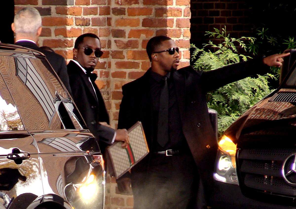 Sean “Diddy” Combs, center, leaves the Columbus Marriott Hotel to attend the funeral of his longtime companion and mother of his four children, Columbus-native Kim Porter, at Cascade Hills Church Saturday.