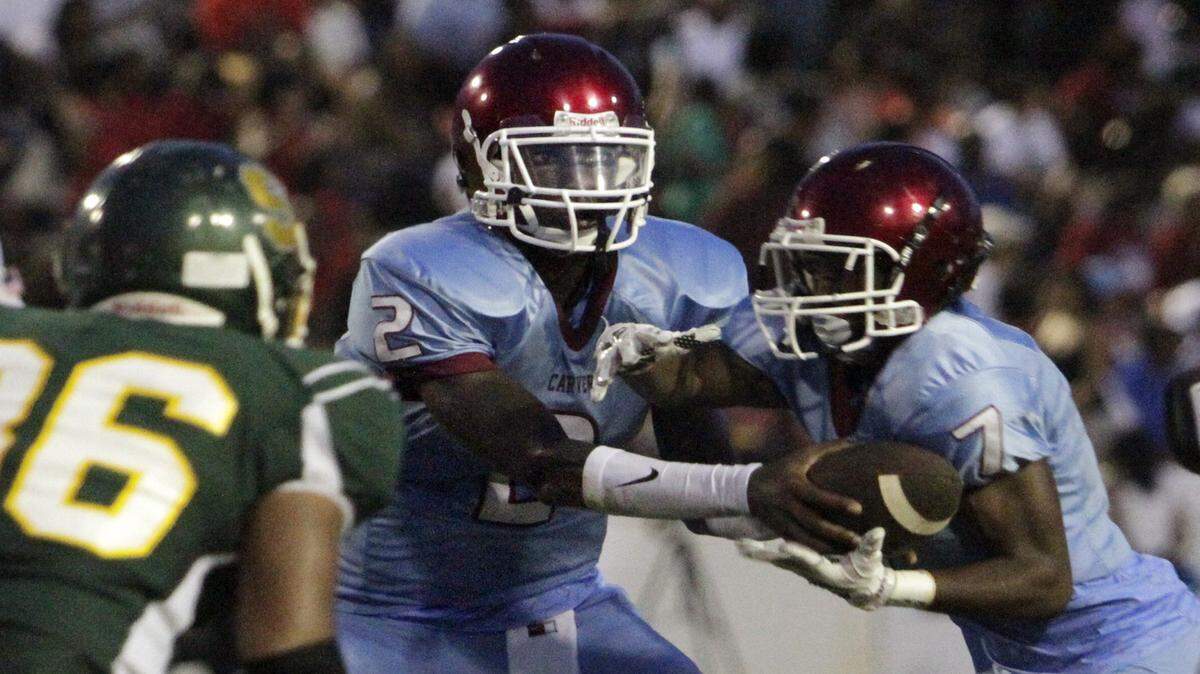 Carver quarterback Jawon Pass hands off to running back Cameron Jessie during first half action against Spencer High Aug. 28 in the 53rd Annual Heritage Bowl at Memorial Stadium Friday.