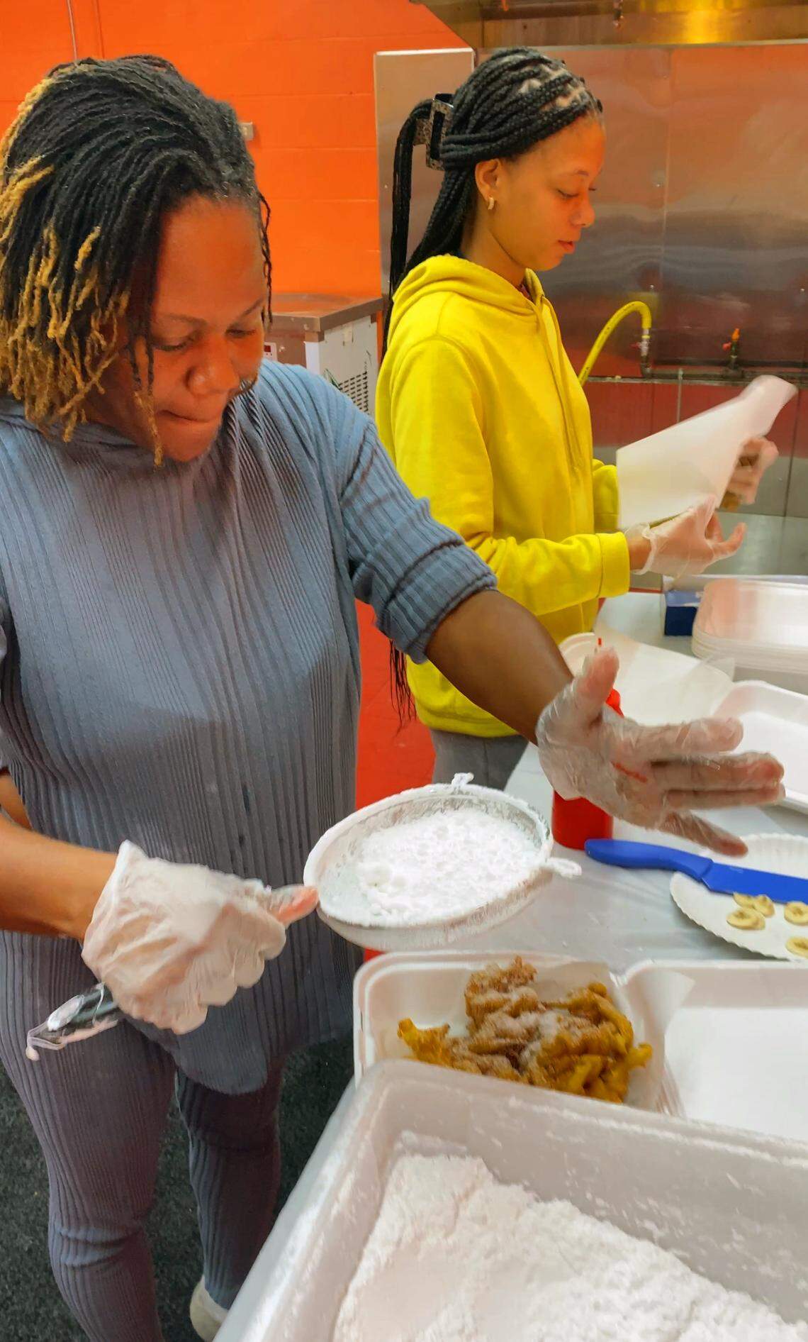 Melita Jefferson, left, the owner of Da Funnel Cake Factory in Columbus, Georgia, makes a traditional funnel cake with powdered sugar. 
