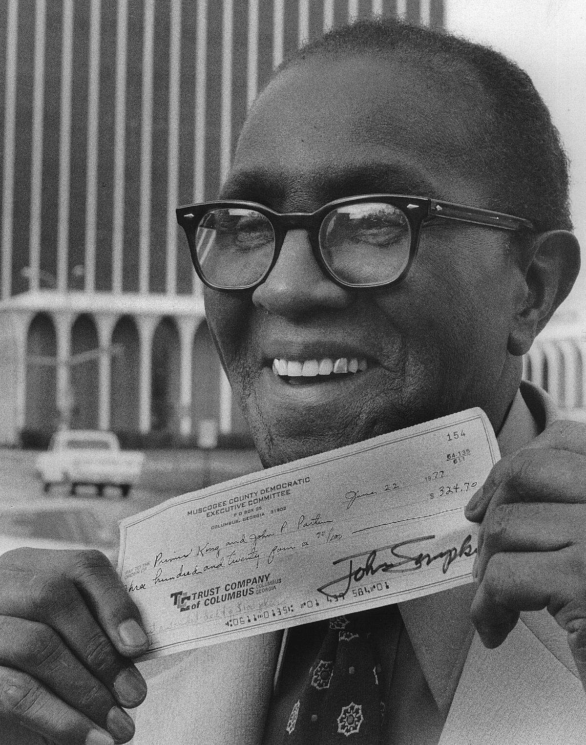 Primus King shows the check he received in 1977 as part of his lawsuit against the Democratic Party in Georgia. The check was owed since 1945.