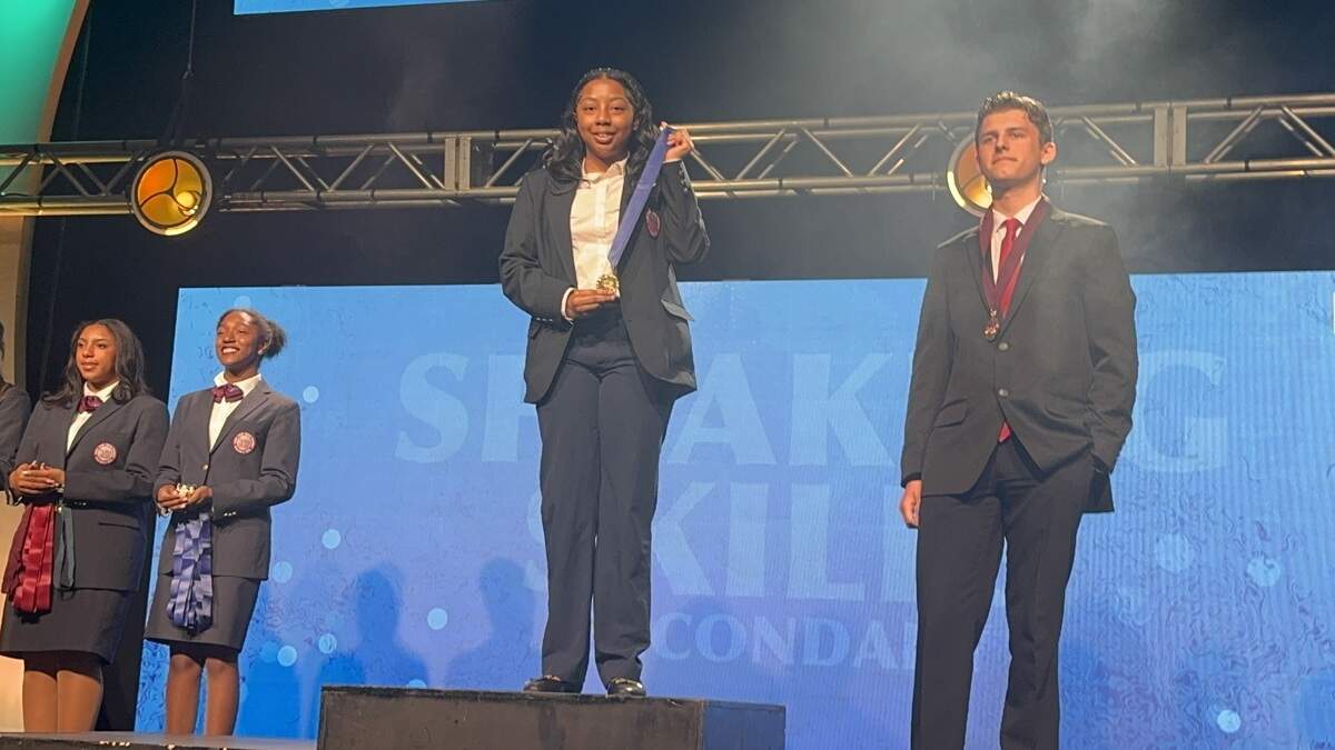 Spencer High School senior Emaureia Mathis of Columbus stands on the podium after winning the speaking skills competition during the 2026 Georgia Health Occupations Students of America State Leadership Conference at the Atlanta Marriott Marquis.