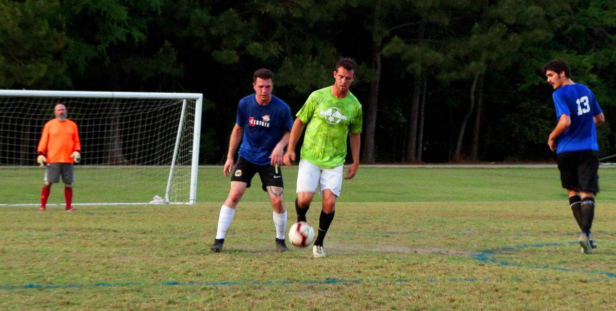 Jacob Crumbley, center wearing green, plays in an adult league soccer game recently at Woodruff Farm Soccer Complex in Columbus, Georgia.