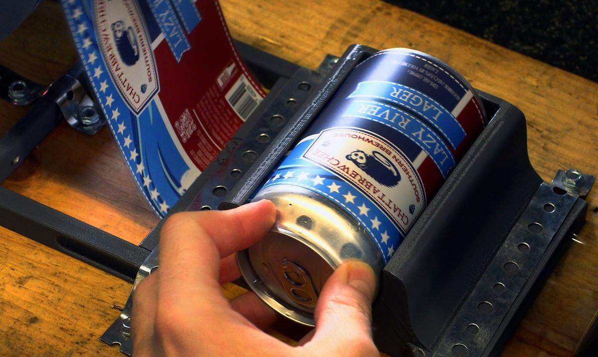 Workers at Chattabrewchee Southern Brewhouse in Columbus, Georgia label nearly 1,000 cans of Chattabrewchee’s Lazy River Lager. 02/28/2024
