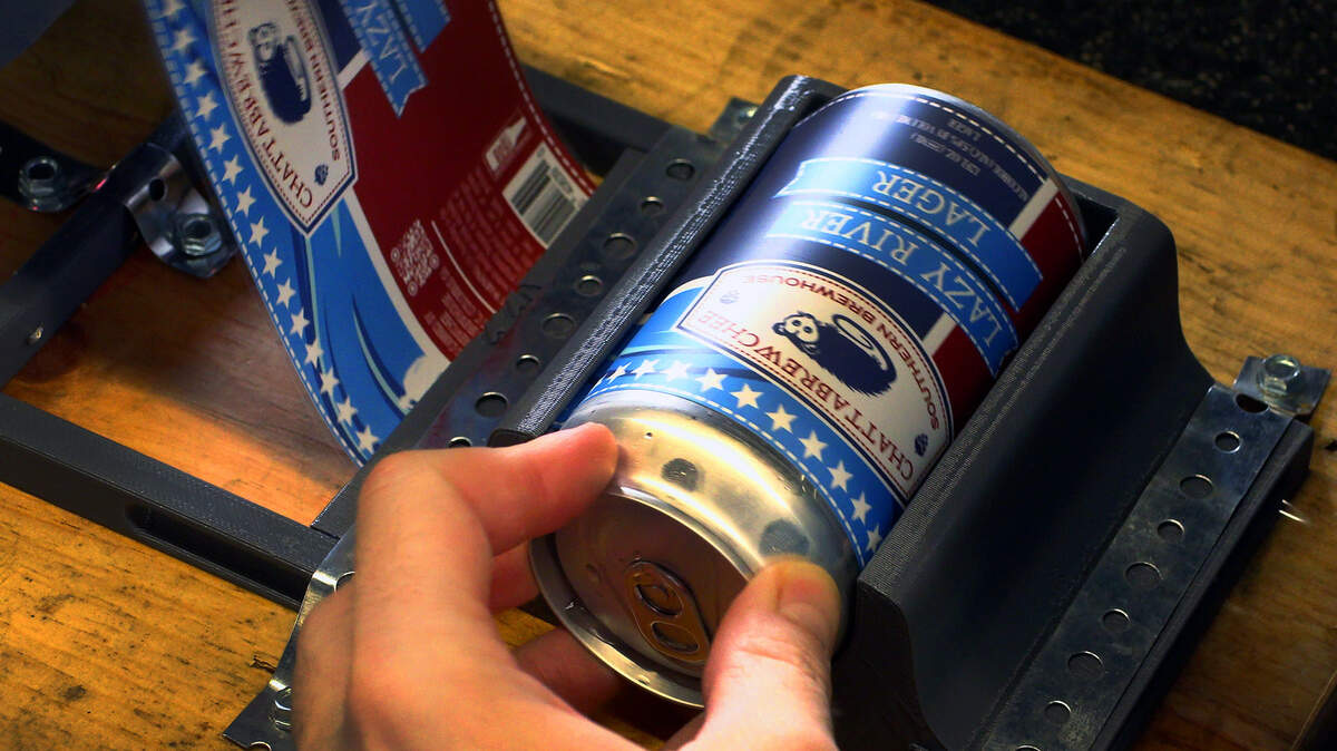 Workers at Chattabrewchee Southern Brewhouse in Columbus, Georgia label nearly 1,000 cans of Chattabrewchee’s Lazy River Lager. 02/28/2024