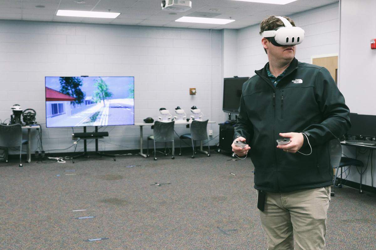 Stephen Turner demonstrates the Weather the Storm virtual reality simulation in the Center for Advanced Computer-Human Ecosystems in January 2024.