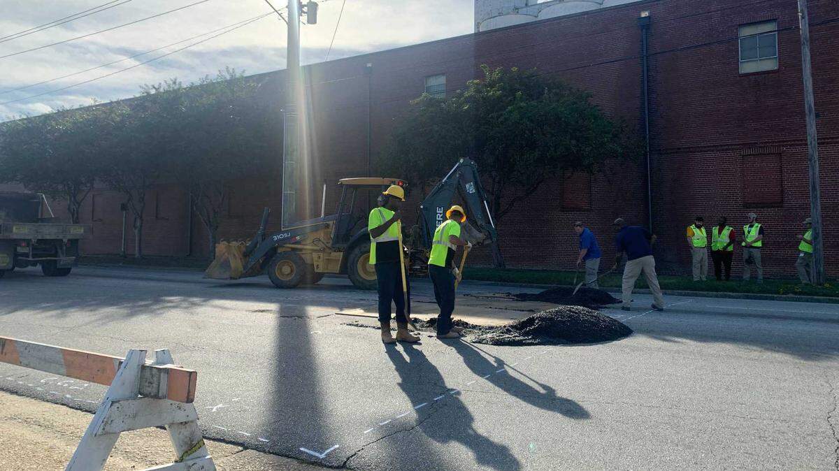 Work crews fill a sinkhole on 10th Avenue near Cusseta Road with asphalt on Nov. 9, 2021.