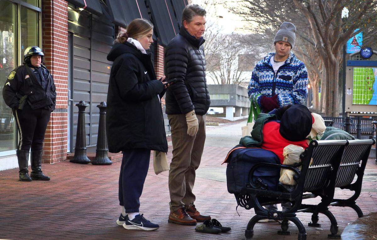 Ben Moser, president and CEO of the United Way of the Chattahoochee Valley, center, and other volunteers speak with a man who was sleeping on a bench in the 1300 block of Broadway in downtown Columbus, Georgia. The United Way of the Chattahoochee Valley’s Home for Good program hosted the 2023 Point In Time Count Jan. 23-24 where volunteers with the annual event survey people experiencing homelessness in the community in an effort to better serve their needs. 01/24/2023