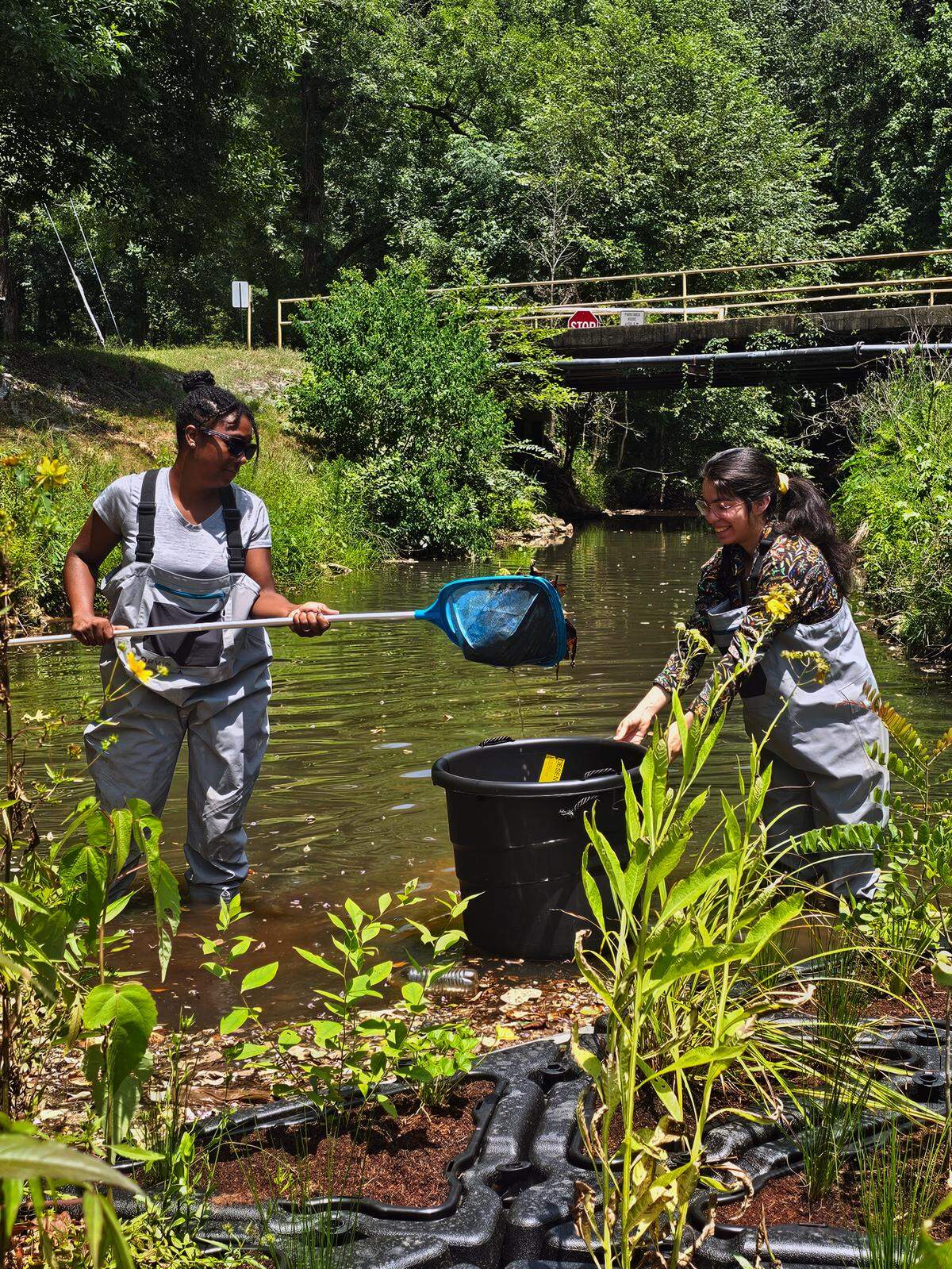 Volunteers collect trash from a trash trap recently installed at Cooper Creek Park in Columbus, Georgia.
