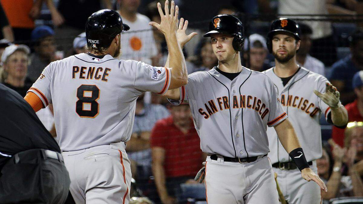 San Francisco Giants' Hunter Pence, left, is high-fived by Buster Posey after Pence hit a three-run home run to score Posey and Matt Duffy during the eighth inning of a baseball game against the Atlanta Braves on Tuesday, Aug. 4, 2015, in Atlanta. (AP Photo/David Goldman)