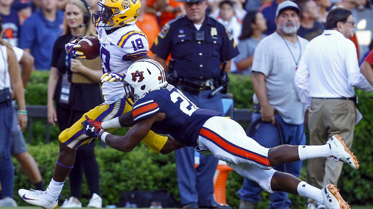LSU wide receiver Derrick Dillon (19) escapes the attempted tackle of Auburn defensive back Jeremiah Dinson (20) and runs for a touchdown during the second half of their game Saturday in Auburn.
