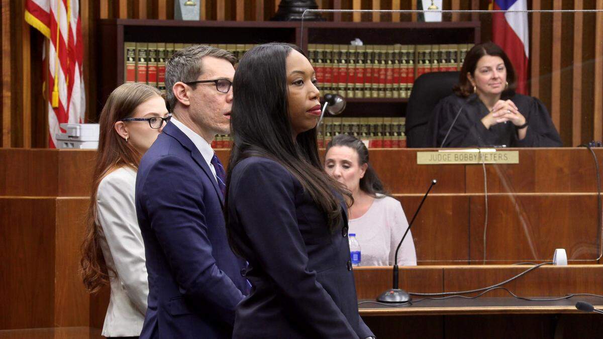 Mark Jones, center, stands with his legal team before Judge Katherine Lumsden as they watch jurors enter the courtroom.