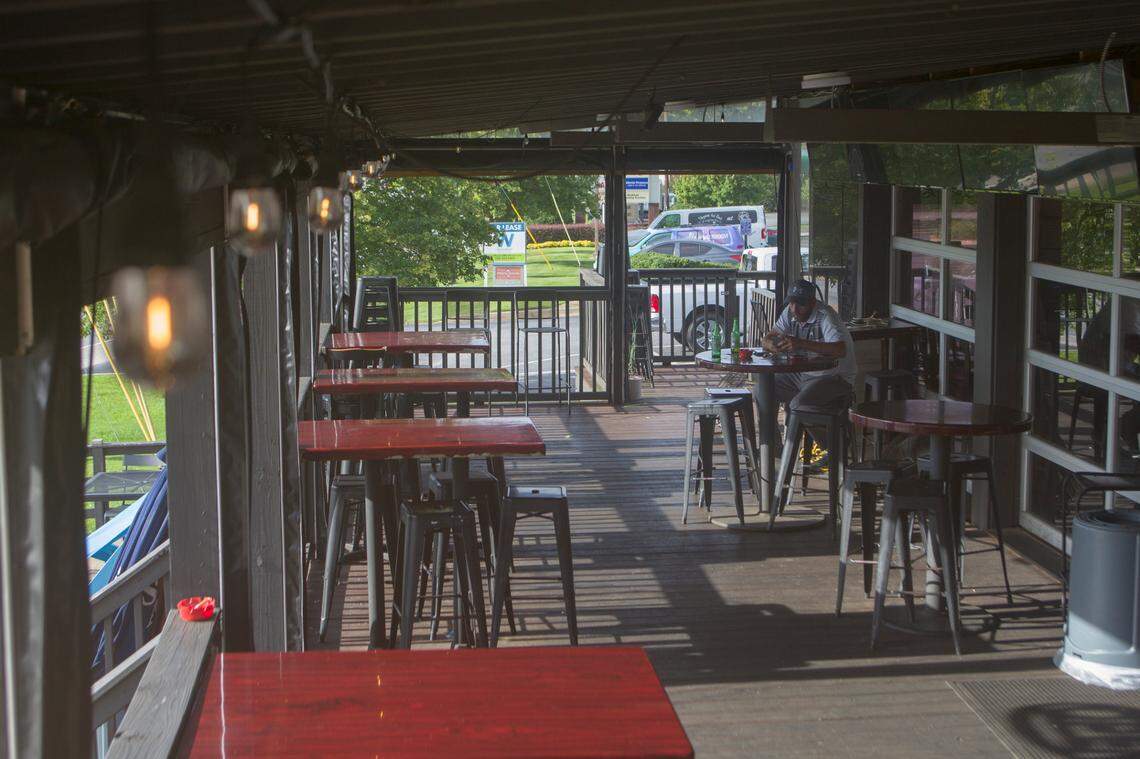 A customer sits on the deck at The Hangout, 6060 Veterans Parkway, in Columbus, Georgia, on June 28, 2021.