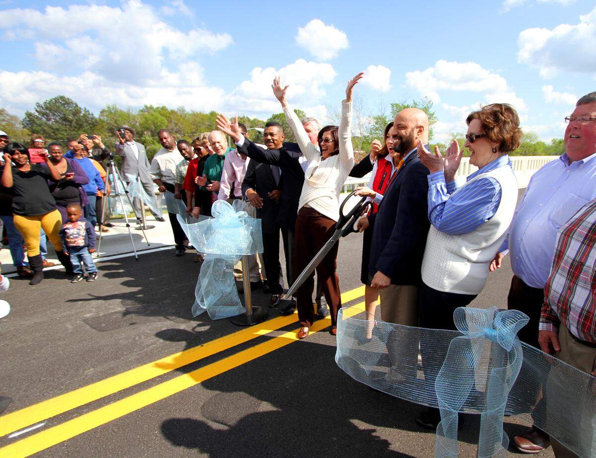 Columbus Councilor Mimi Woodson, whose district includes the Brown Avenue Bridge, throws her hands in the air as she and other local leaders cut the ribbon on the new bridge on March 30, 2015.
