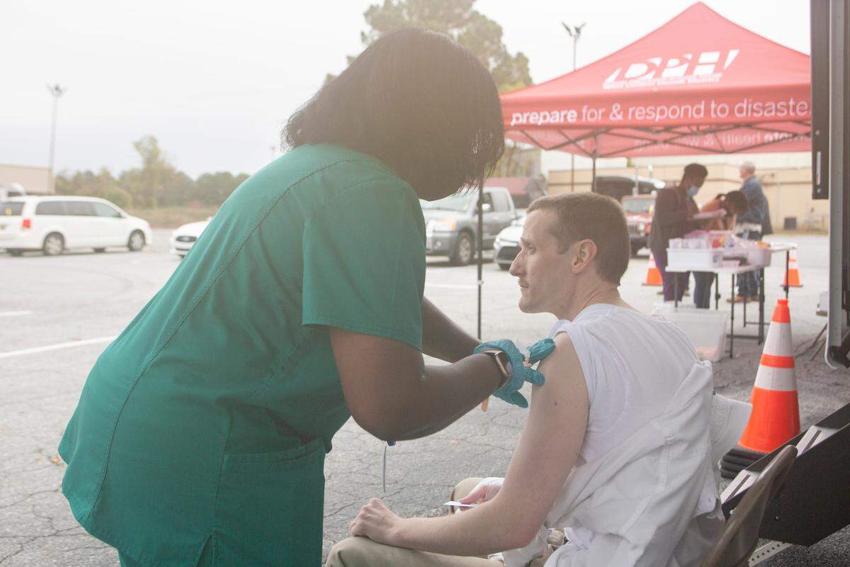 Piggly Wiggly store manager Fred Biser receives the Johnson & Johnson vaccine in the River Road store’s parking lot, on Dec. 7, 2021, in Columbus, Ga. The health department’s mobile unit is traveling across the West Central Health District to offer COVID-19 vaccines and the flu shot to Georgians.
