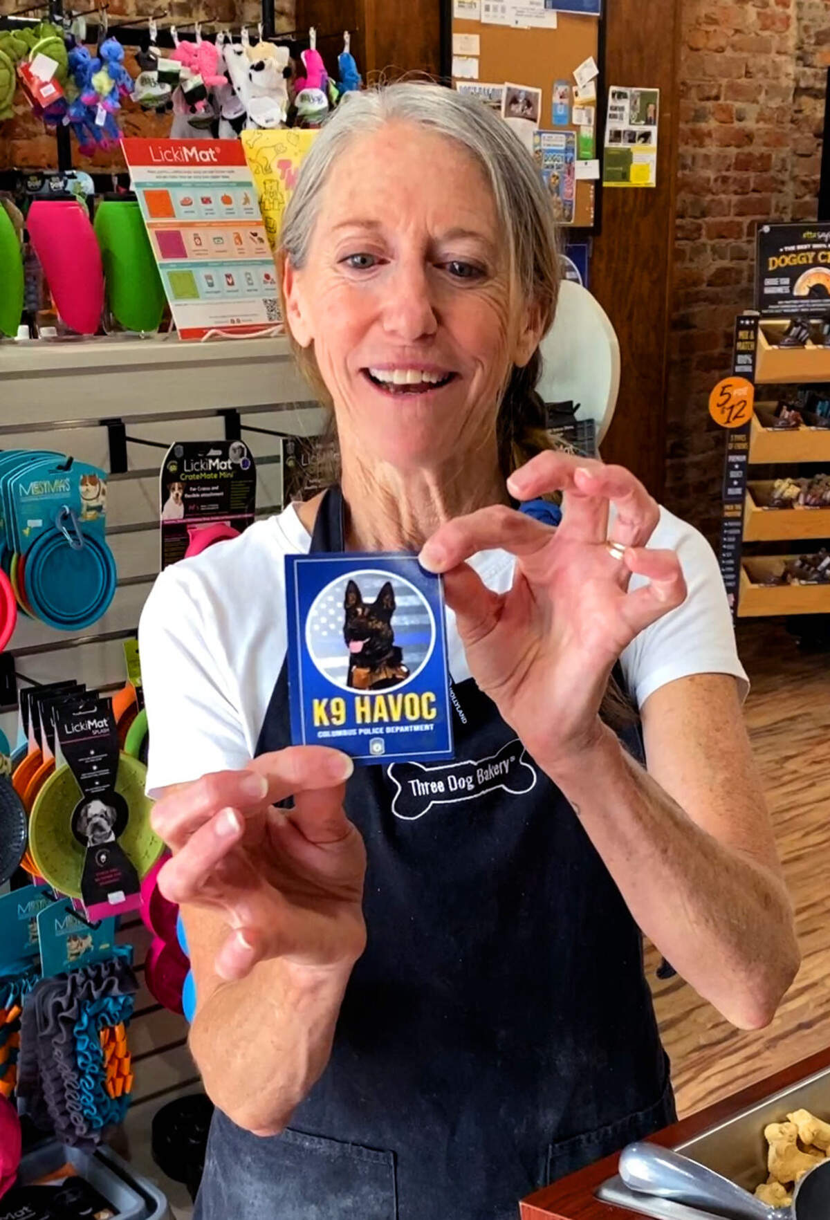 Tracy St. John, pictured June 25, 2026, shows the trading card for K9 officer Havoc with the Columbus Police Department.