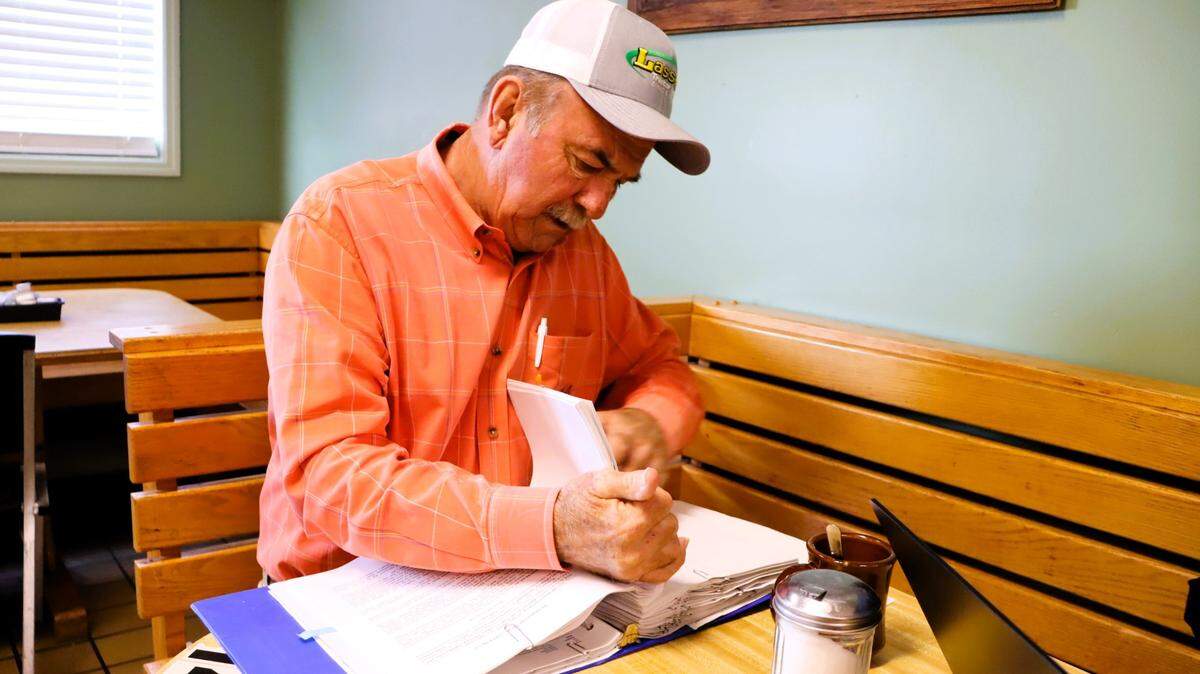 Rusty Blackston sorts through his binder of notes and paperwork about the Brightmark Thomaston Circularity Center at a restaurant in Thomaston in April 2025.